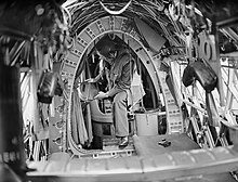A crewman on board a World War 2 Royal Air Force Vickers Wellington bomber. The container to the right of him is the aircraft's "Elsan" chemical toilet (1939-1941) Vickers Wellington - Royal Air Force Bomber Command, 1939-1941. CH478.jpg