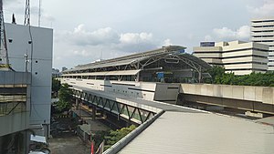 Bangunan Stasiun MRT ASEAN, menampilkan bangunan stasiun yang melintang di atas jalan raya, berserta bangunan tinggi di sekelilingnya