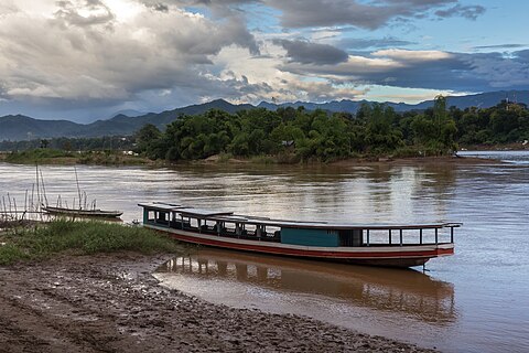 Boats on the Mekong bank with clouds and blue sky in the late afternoon in Luang Prabang Laos