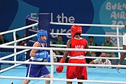 Deutsch: Boxen bei den Olympischen Jugendspielen 2018 Tag 12, 18. Oktober 2018 - Finale Fliegengewicht Mädchen – Martina La Piana (Italien, blau) schlägt Adijat Gbadamosi (Nigeria, rot) 5-0; Ringrichter ist James Beckles (Trinidad und Tobago). English: Boxing at the 2018 Summer Youth Olympics on 18 October 2018 – Girl's flyweight Gold Medal Bout - Martina La Piana (Italy, blue) beats Adijat Gbadamosi (Nigeria, red) 5-0; Referee is James Beckles (Trinidad and Tobago). Español: Boxeo en los Juegos Olímpicos Juveniles de Verano de 2018 en 18 de octubre de 2018 - Combate a medalla de oro de peso mosca para mujeres: Martina La Piana (Italia, azul) le gana a Adijat Gbadamosi (Nigeria, roja) 5-0; El árbitro es James Beckles (Trinidad y Tobago).