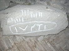 Granitstein in der Church of St James, St Kew; Latein- und Oghaminschrift (I)USTI (von links nach rechts) – 600 n. Chr.