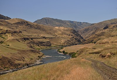 Narrow river turning between brown hills