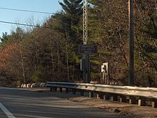 The Jerimoth Hill sign along Route 101 at the entrance to the path to the actual highpoint.