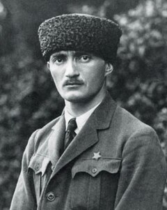 Image of a man from the shoulders up. He is wearing a fur hat and looks directly at the camera