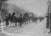 Bajo la nieve avanza el coche fúnebre tirado por cuatro caballos enjaezados de luto y escoltados por aguijones