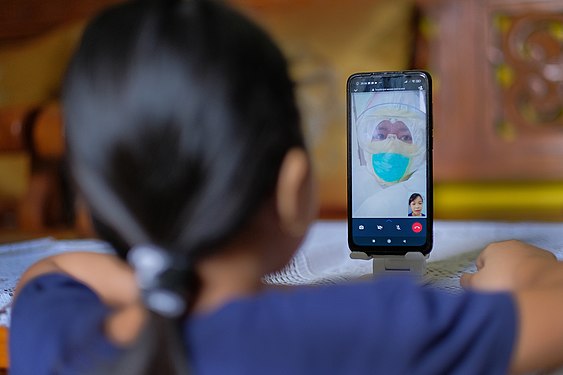 A CHILD DOING A VIDEO CALL WITH HIS MOTHER AS A NURSE IN A COVID ROOM