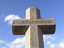 To mark the millennium in 2000, a cross was erected in each of the 12 parishes to replace the wayside crosses that fell subject to the iconoclasm of the 16th century. Here, the millennium cross of Saint Helier bears the Jerriais inscription A la glouaithe de Dgieu (To the glory of God). Millennium cross St Helier Jersey.jpg