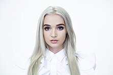 Poppy in front of a pure white background, characteristic of her YouTube videos POPPY PRESS PHOTO.jpg