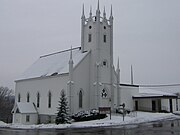 Petitcodiac Baptist Church on the banks of the Petitcodiac River. It was demolished in 2016 and rebuilt (new design) in 2018. Petitcodiac Baptist Church.jpg