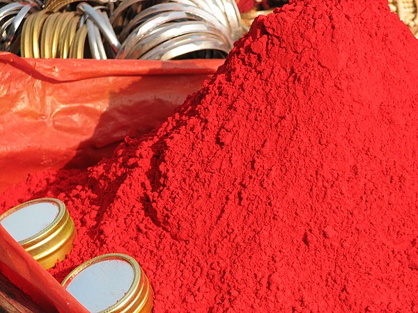 Vermilion is similar to scarlet, but slightly more orange. This is sindoor, a red cosmetic powder used in India; some Hindu women put a stripe of sindoor in their hair to show they are married.[5][6]