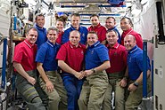 STS-132 (blue shirts) and Expedition 23 crew members pose for a group portrait on the ISS.