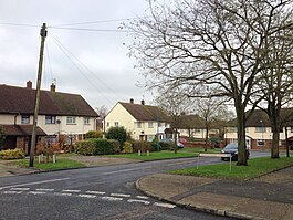 A photograph of a cul-de-sac with large houses and some greenery