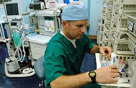 US Navy 080619-N-1328S-001 Cmdr. Trent Douglas, a staff plastic surgeon assigned to the Military Sealift Command hospital ship USNS Mercy (T-AH 19), sorts through surgical equipment before scheduled shipboard surgeries.jpg