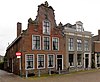 Kingmahuizen, twee panden, beide onder zadeldak, de rechter (nr. 20) met gepleisterde lijstgevel met rechte kroonlijst en de linker (nr. 22) met halsgevel met gebeeldhouwde klauwstukken en bekroning