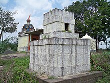 a 5 foot square, castle-like white tomb of stone blocks