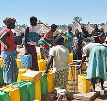 Women line up at a bore hole to fill their containers with water (Labuje IDP camp, Kitgum, Kitgum District, Northern Region of Uganda) Water Lebuje camp, Uganda.jpg
