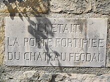 Photographie en couleurs d'une plaque apposée sur un bâtiment et gravée d'une inscription.