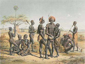 A group of Shilluk in around 1860, just before the fall of the kingdom. Men were either naked or wore the skins of cats or young lambs, while women and children wore calf skins. A group of Shilluk, ca 1860.jpg