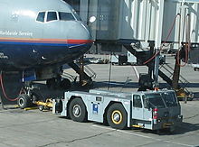 A conventional tractor hooked up to a United Airlines Boeing 777-200ER at Denver International Airport Airplane pushing vehicle.jpg