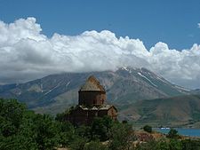 Abandoned since 1915, the tenth-century Armenian Cathedral of the Holy Cross on Akhtamar Island underwent a controversial restoration in 2006, paid for by the Turkish Ministry of Culture. Akdamar and mountain.jpg