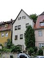 Wohnhaus (ehemaliges Diakonatshaus) in geschlossener Bebauung, mit Stützmauer