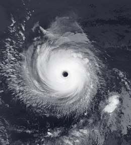 A view of a hurricane over open waters from Space. The hurricane is well-developed, with a symmetric cloud pattern and a well-defined eye at the center.