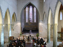 A Lutheran priest in Germany marries a young couple at the church. Ev Stadtkirche Ravensburg innen.jpg