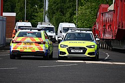 Two South Yorkshire Police Audi A6s prepare to escort a transformer abnormal load out from Albert Dock in Kingston upon Hull towards the Dogger Bank Convertor Station.