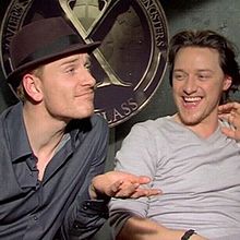 Michael Fassbender en James McAvoy zitten voor het "X"-logo voor Xaviers school.