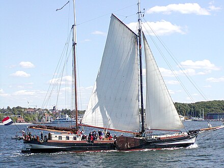 A Dutch sailing barge showing its stowed windward leeboard, hiked up with wind from starboard