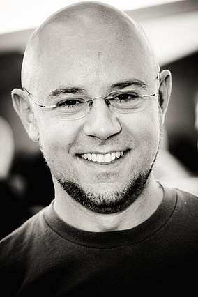 Bald man with glasses smiling