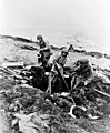 Attu, Aleutian Island, June 4, 1943. US soldiers hurling their trench mortar shells over a ridge into a Japanese position.