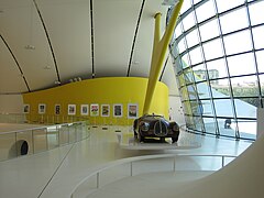 Fotografia de um Auto Avio Costruzioni 815 em exibição na entrada do museu Enzo Ferrari.