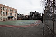 A schoolyard with basketball hoops and a painted running track