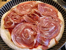 Pizza prepared with sliced rolled pancetta with capicola (pancetta coppata)
