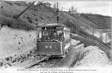Motor N 6 in the "Cavee" ("cutting"). The rails and sleepers can be easily seen, with another track at a lower level on the right of the picture, as well as the funicular and its terminus, further back. ROUEN - tramways de Rouen a Bon-Secours... dans la Cavee - Vue sur la colline de Bon-Secours.JPG