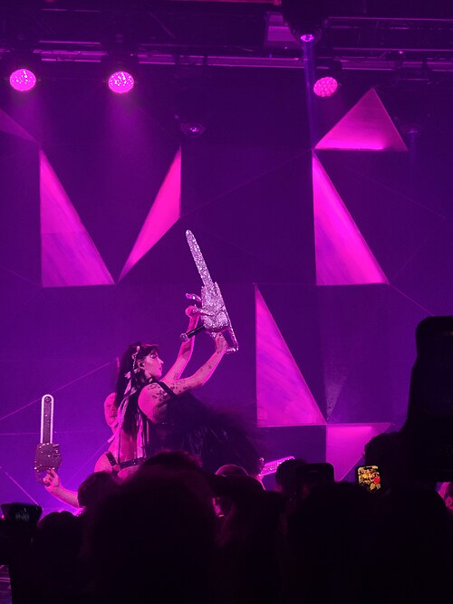 Black wielding a rhinestone encrusted chainsaw while performing at Elsewhere in Brooklyn on her 2023 Let Her Burn tour.