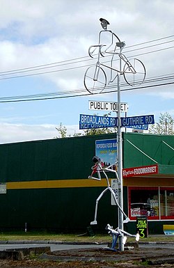 Straßenschild und Skulptur