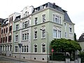 Tenement house in a corner and half-open development, with lateral fencing