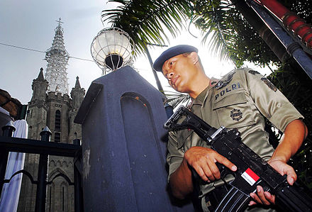 An Indonesian Armed BRIMOB special Police personnel with a Pindad SS1 assault rifle guarding outside the Jakarta Cathedral