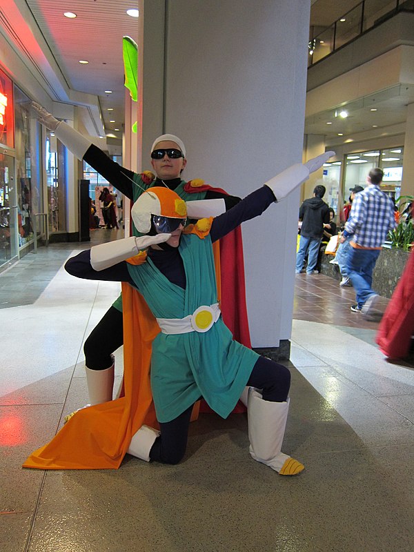 Cosplayers portraying Gohan (back) and Videl (front) in their respective Great Saiyaman costumes.
