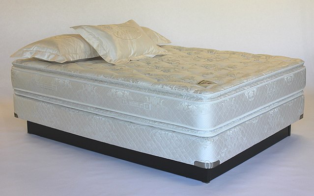 Two-sided, innerspring pillow-top mattress on box-spring foundation with a woven damask cover also called a mattress sheet