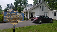 a picture of the marker, with a not-very old modern home, car in driveway, in the background