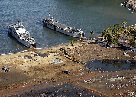 US Navy 050109-N-4166B-101 Indonesian Navy landing craft and a U.S. Navy Seahawk helicopter deliver relief supplies and evacuate Indonesian citizens in Tjalang, Sumatra, Indonesia.jpg