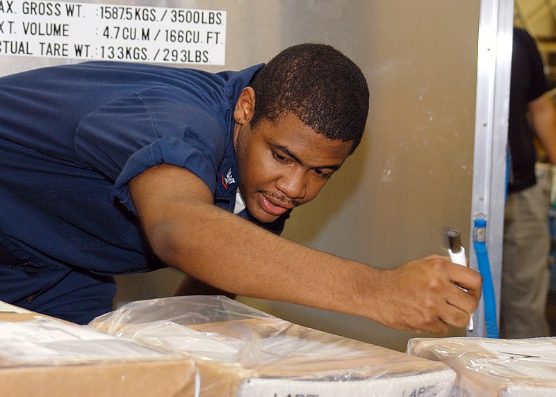 File:US Navy 060828-N-2716P-009 Postal Clerk 3rd Class Samuel Anderson calls out the destination of an incoming package and marks the parcel accordingly during mail distribution at Fleet Mail Center, Yokohama.jpg