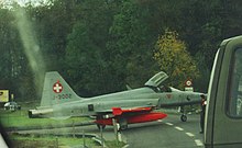 A Swiss Air Force F-5E Tiger II crossing a road between the runway and an aircraft cavern (Mollis airfield, 1999). X-street.jpg