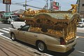 車体が金色に塗られた宮型霊柩車