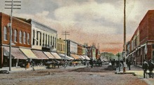 Looking south on Iowa Avenue along Dubuque toward the Englert family's Bon Ton cafe at 24-26 South Dubuque Street. The cafe appears as a brownish-colored building on the east (left) face near the center of this 1907 postcard image. Dubuque St 1907 view S from IA Ave in Iowa City, Iowa.tif