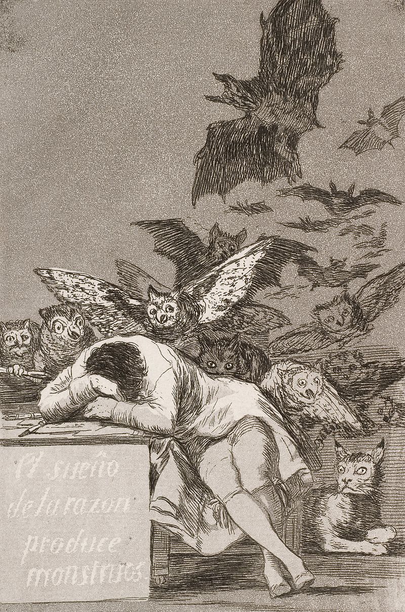 a man sleeping at a table is encumbered by bats and owls and cats behind him. the table is inscribed with the spanish phrase - the sleep of reason produces monsters