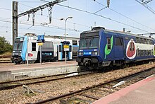 Două trenuri în stația Malesherbes: livrea Île-de-France Mobilités pe stânga și Transilien pe dreapta.